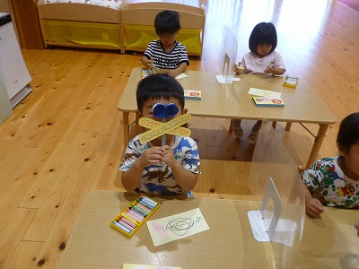 トンボの眼鏡を覗く園児