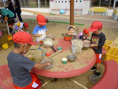 砂場でお料理作りをする園児