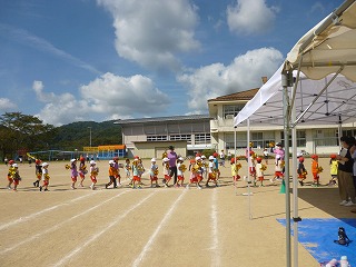 小学校の運動場で練習する園児