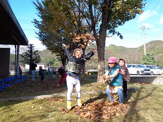 葉っぱで遊ぶ園児