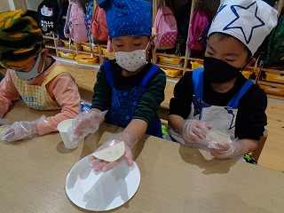 包めた餃子を見せる園児