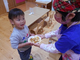 うさぎ組保育室で餃子を渡す園児