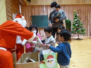 サンタさんからプレゼントをもらう園児