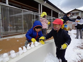 雪だるまを並べる園児