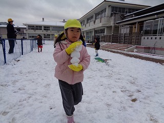 雪玉を集める園児