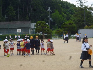 小学校のｌ校庭で、小学生と遊ぶ園児