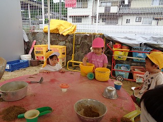 砂でお料理ごっこをする園児