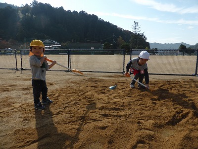 真砂土を園庭に広げる園児